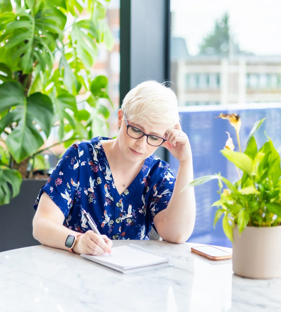 Jenny writing in a notebook at a table